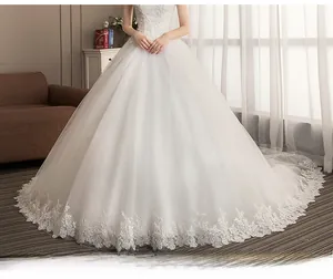 Detailed view of the elegant lace hem and long bridal train on white wedding dress