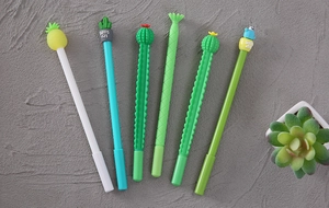 Detailed view of 6-piece novelty cactus and pineapple gel pens on a textured background