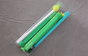 Close-up of cartoon cactus and pineapple gel pens in a transparent plastic case