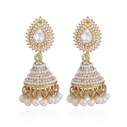 Detailed macro shot of gold Jhumka earrings with white pearls and sparkling rhinestones