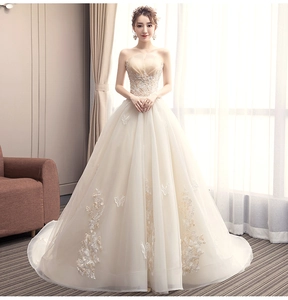Close-up of champagne strapless wedding dress with butterfly embroidery and lace