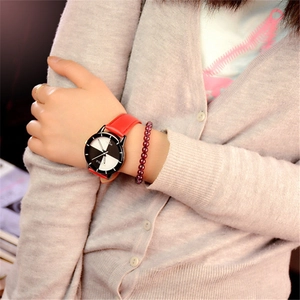 Minimalist quartz watch with red leather strap and black white dial on model's wrist