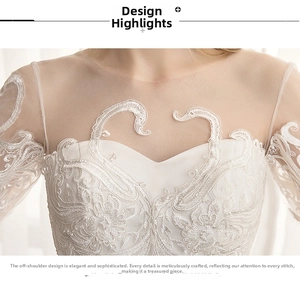Close-up of white off-the-shoulder wedding dress with intricate swan lace embroidery details