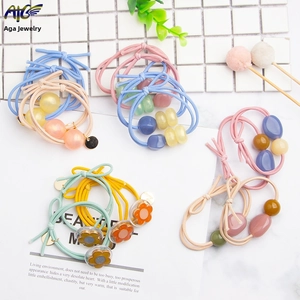 Detail showing macaron color elastic hair ties with matte beads and acrylic flowers