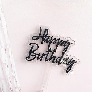 Detail shot of black acrylic Happy Birthday cake topper with transparent stand