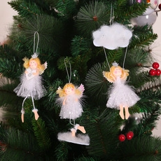 Detailed view of three white Christmas angel ornaments hanging on a festive tree