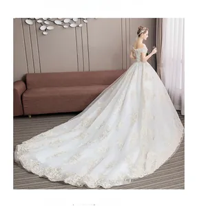 Detail of off-shoulder wedding gown featuring champagne gold floral lace embroidery