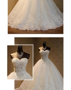 Detail of white ballgown wedding dress showing intricate lace flower and sequin embroidery