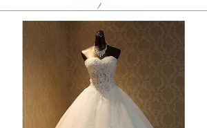 Close-up of white strapless wedding dress with intricate floral lace and beadwork details