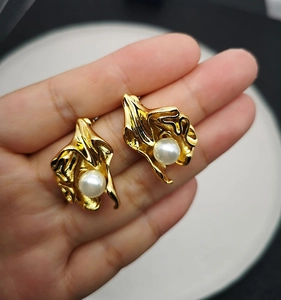 Detailed view of handmade gold-plated brass flower earrings with embedded pearls