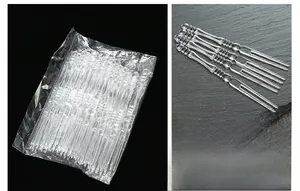 Macro shot of two-pronged disposable clear plastic fruit forks with textured handles