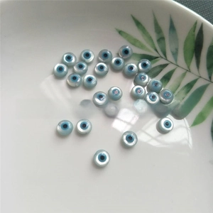 Macro shot of flat round evil eye beads made of natural light blue mother of pearl shells