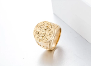 Detailed view of Saint Benedict medal relief on golden stainless steel cross ring for men