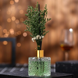 Lavender reed diffuser in textured glass bottle with gold cap and green dried flowers