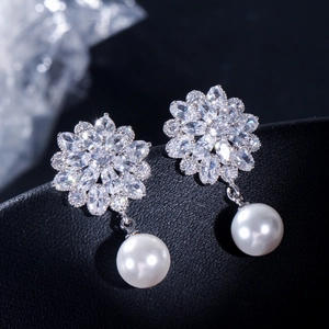 Macro detail of bridal flower earrings with marquise zircons and white pearls