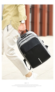 Man holding a grey and black anti-theft backpack with a combination lock detail