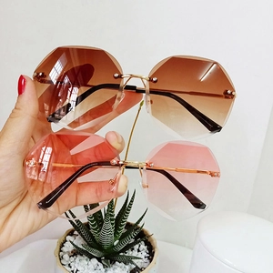 Detail showing two pairs of rimless octagonal sunglasses with gradient tinted lenses