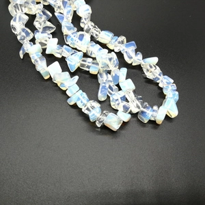 Macro shot of irregular opalite stone chips showing iridescent blue and orange glow