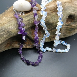Detailed close-up of irregular amethyst and opal chip bead necklaces on wood