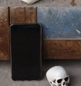 Detailed realistic skull prop with weathered finish shown with phone for scale