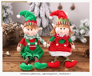 Detailed view of Christmas elf plush dolls in red and green festive outfits on wood