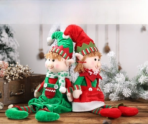 Detailed plush Christmas elves set with red and green velvet outfits on wood surface