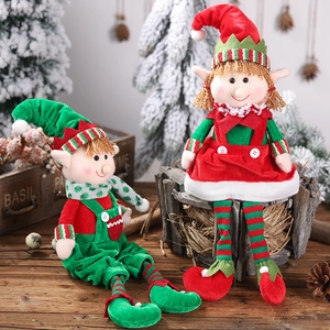 Detailed close-up of plush Christmas elf dolls on rustic wood with snowy trees decor