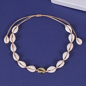 Natural shell choker set with golden accent and adjustable woven beige cord on blue background