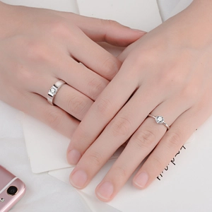 Classic silver couple rings with sparkling zircon stones worn on hand for engagement