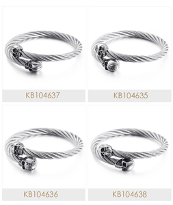Detail of four stainless steel braided wire bracelets with skull and ball end charms