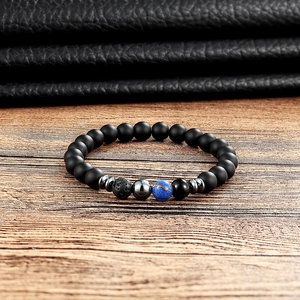 Macro detail of matte black agate beads and blue veined stone on a beaded yoga bracelet
