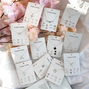 Detailed set of silver-tone necklaces and stud earrings with heart and wing charms
