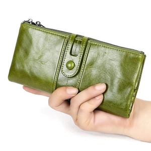Detail of green oil wax leather wallet texture with metal zipper and snap button strap