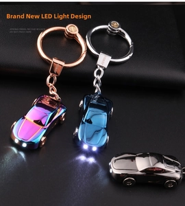 Detail of metal car keychain with glowing LED headlights in colorful finishes
