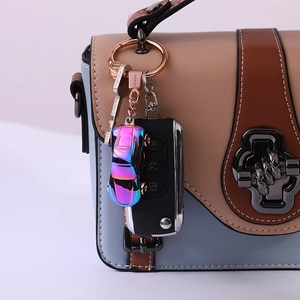 Car-shaped metal keychain with colorful gradient finish and LED light on a handbag