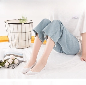 Close-up of white cotton low cut invisible socks worn in a cozy home setting