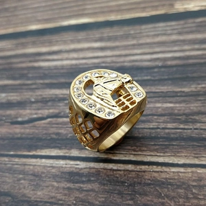 Macro shot of gold-plated horse head ring with sparkling rhinestones on wood