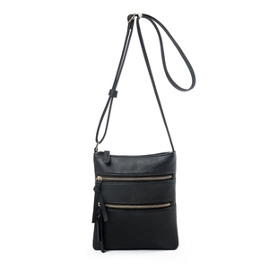 Close-up of black crossbody bag with three parallel metal zippers and pebble leather texture