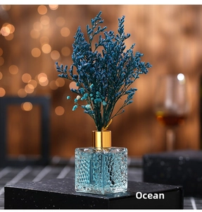 Detailed macro of the blue dried flower reed diffuser with ocean scent and glass bottle