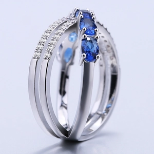 Silver X-shaped ring for women featuring blue oval-cut zircon and pave accents