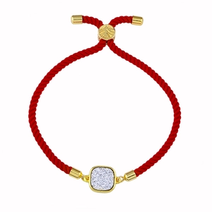 Détail du bracelet en cordon tressé rouge avec cristal doré et fermoir réglable coulissant
