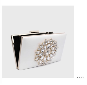 Detail view of a white satin evening bag with sparkling rhinestone and gold metal frame