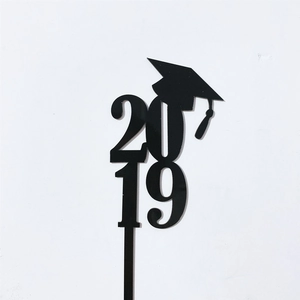 Detail of black acrylic graduation cake topper with 2019 digits and a graduation cap