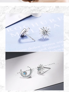 Detail of silver sun and moon earrings with clear zircons and blue center stone