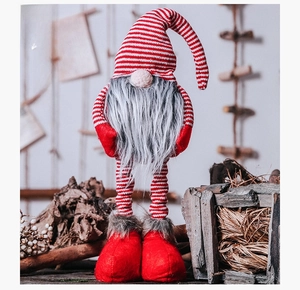 Detail of Christmas gnome plush with red striped hat and long grey faux beard decor