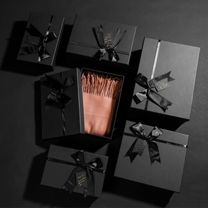 Close-up of premium black kraft paper jewelry boxes with elegant satin bows and silk scarf