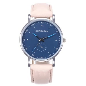 Montre à quartz moderne avec cadran bleu foncé et bracelet en cuir rose sur blanc