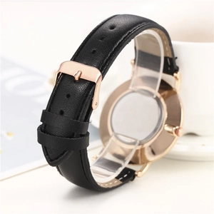 Détail du bracelet de montre en cuir noir avec texture litchi et boucle rose doré
