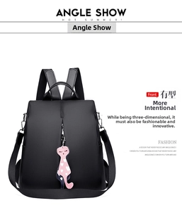 Detail of black waterproof nylon backpack with a pink cat charm and white heart pattern