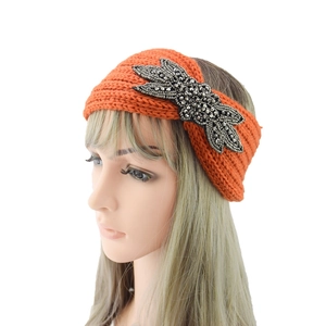 Detail der orangefarbenen Strickstirnbandes mit handgefertigter Libelle aus Perlen